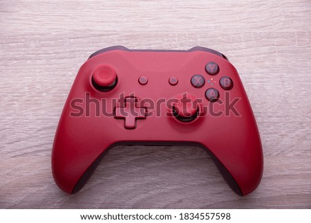 Red controller isolated on wood background
