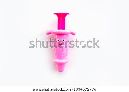 Childrens toy syringe pink isolated object on white background. Top view
