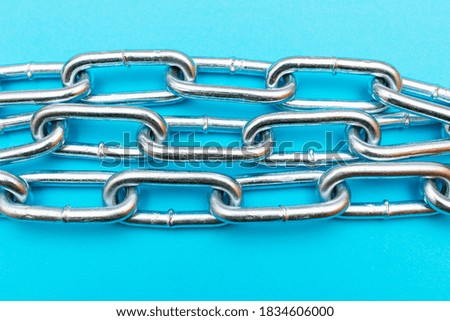 Top view Close-up metal chain lies on the blue background .Studio image.