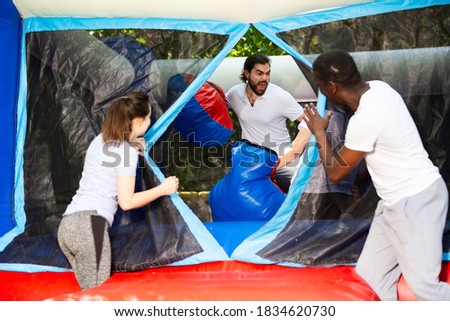 Adult fun friends box in huge boxing gloves in an amusement park. High quality photo