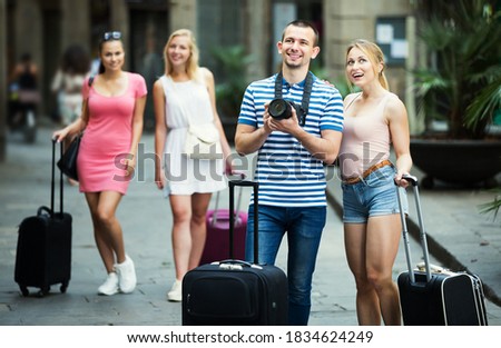 Young smiling couple taking picture with camera in town while traveling