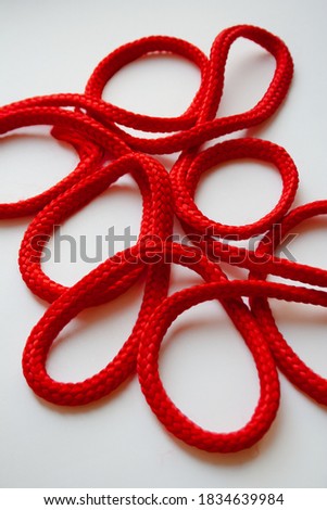 Red textured curled cable on white background