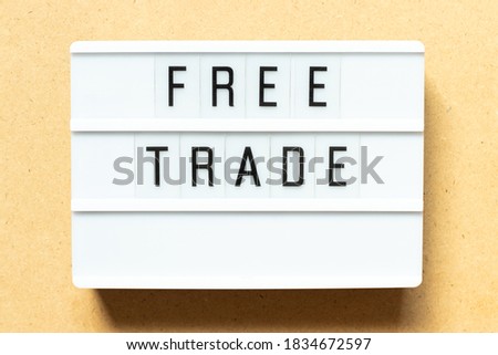 Lightbox with word free trade on wood background