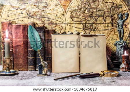 open antique book on which a magnifying glass rests. are found on a wooden desk on leather. Two lighted lanterns are incorporated to illuminate with a candle and two other writing pens