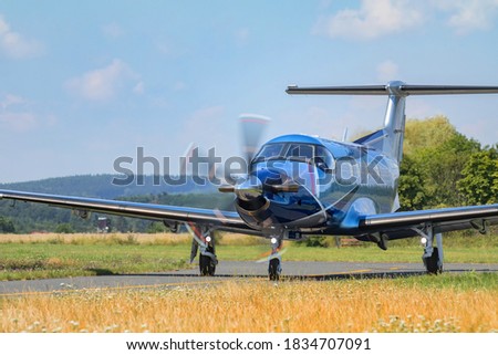Single-engine turboprop blue airplane. Blue Airplane on runway. Front View. Royalty-Free Stock Photo #1834707091