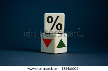 Wooden cubes changes the direction of an arrow symbolizing that the interest rates are going down or vice versa . Business concept. Copy space, beautiful grey background. Royalty-Free Stock Photo #1834800394