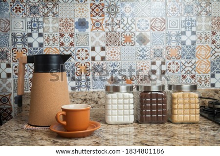 Breakfast table with coffee thermos, cup and pots of sugar, coffee and condiments. Typical Brazilian cuisine with tiles decorated in the background. Food concept. Breakfast concept. 