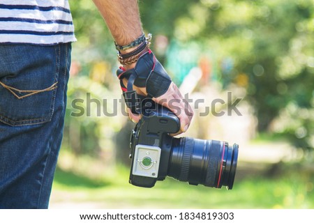 photographer carrying digital camera in hand
