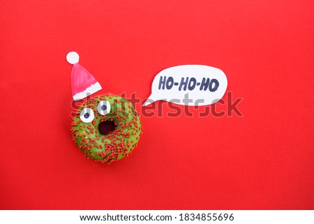 xmass new year donat santa claus with party hat. for present card or invitation of party. festival red background. child food. 