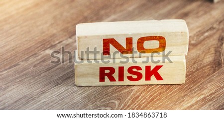 No Risk words on wooden blocks on wooden table. Risk management concept.