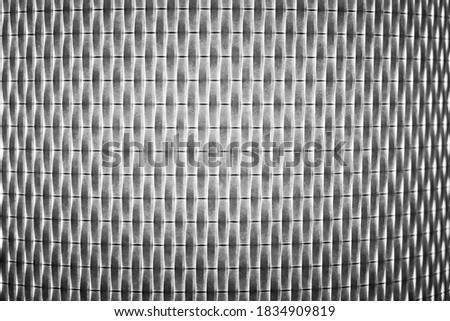 A black and white close up of the repeating pattern of a light shade creates interesting and unusual shapes. Perfect for a textured background.