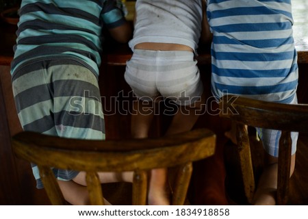 three kids sitting on there backs Royalty-Free Stock Photo #1834918858