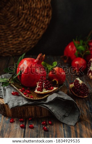 Red pomegranate fruits under water splash on a wooden background Royalty-Free Stock Photo #1834929535