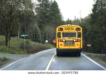 A school bus stops on a rural road to let off students