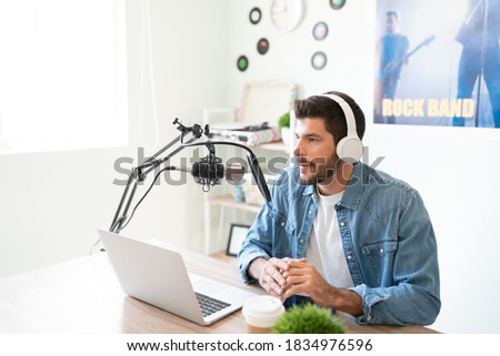 Hispanic radio host and broadcaster looking serious while talking about an important topic during a live podcast