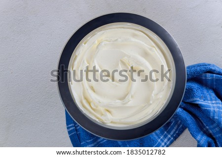 Homemade vanilla whipped cream in a bowl with blue towel. Top view.