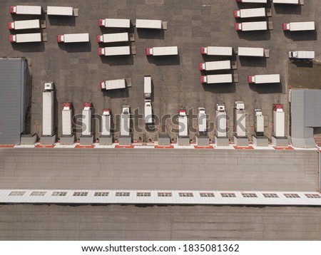 Aerial Top View of White Semi Truck with Cargo Trailer Parking with Other Trucks.