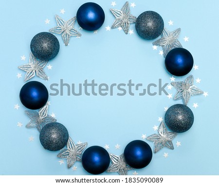 Christmas or new year composition. Round frame made of christmas decoration on blue background. Holiday and celebration concept for postcard or invitation. Top view 