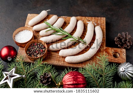 Christmas sausages on a background of stone with branches Christmas trees, toys, gifts