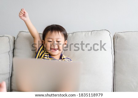 Asian toddler boy student study online education.Kid watching cartoon video streaming.Happy boy learn english online with laptop at home.New normal.Covid-19 coronavirus.Social distancing.stay home.