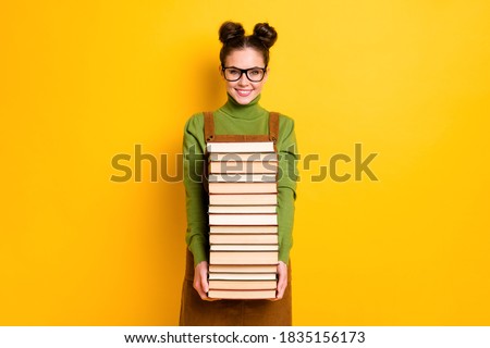 Portrait of her she attractive brainy diligent cheerful girl nerd carrying, many book 1 September new year semester grade isolated bright vivid shine vibrant yellow color background