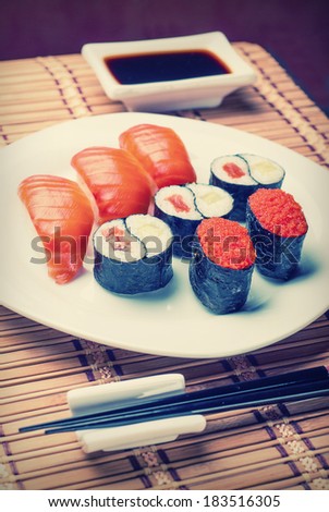 Vintage picture. Sushi and rolls on a plate with soy sauce