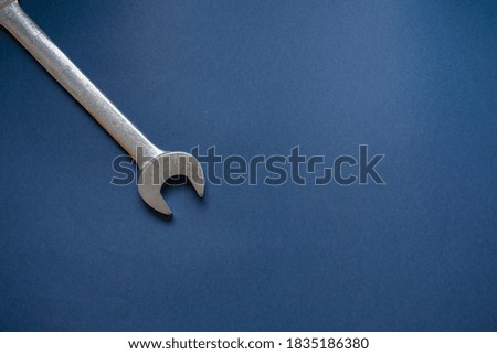 A big wrench appears on the top left corner, over a dark blue background Royalty-Free Stock Photo #1835186380