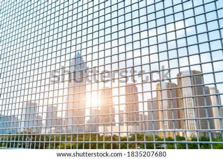   See the blurry city buildings through the iron net
