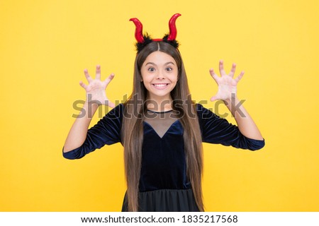 I will eat you. child in imp horns on yellow background. kid wear devil horns show claws. childhood autumn holiday. funny teen girl ready to celebrate party. costume party fun. happy halloween.