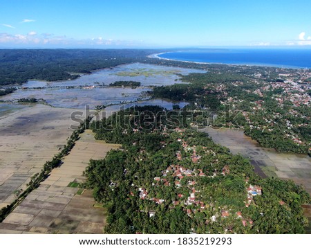 Magnificent aerial drone view of Pangandaran Beach with sunny clear blue sky, clouds, sea waves in West Java, Indonesia
