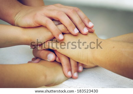 Many hands piled on top of one another in a sign of trustful friendship 