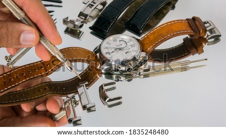 Watchmaker using spring bar tool. Spring bar tool used to remove spring bars to change watch strap.