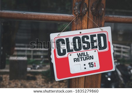 Text on white sign board  “Closed” infront of the mirror’s  shop with the boken yellow and green bright background. The mirror is dirty ,full of rusty and dusts. 