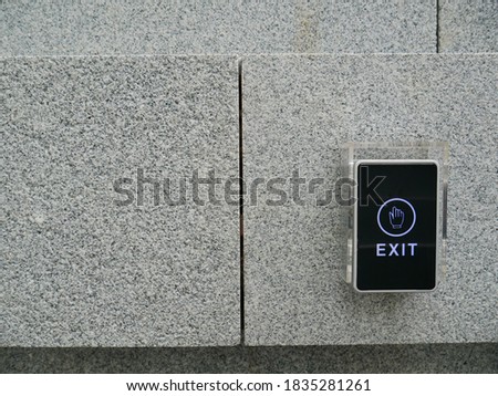 an electronic exit door switch attached on granite wall outdoor without roof 