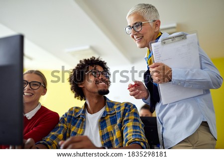 Female professor helping students at the informatics lecture in the university computer classroom Royalty-Free Stock Photo #1835298181