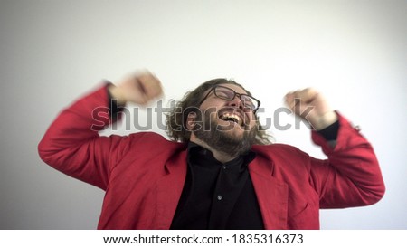 A young man with glasses is very emotionally happy about success.White background.