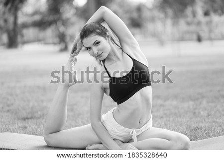 Girl doing yoga in the park during the day. Black and white photo. BW