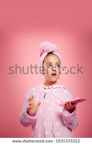 girl in a pink terry dressing gown and with a towel wrapped around her head
