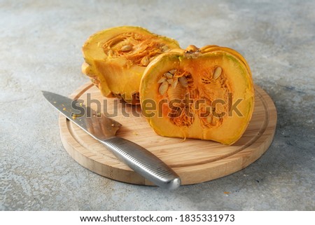Halved Kamo-Kamo pumpkin or squash with seeds on a kitchen board, seasonal vegetable for a delicious autumn dish, copy space, selected focus, narrow depth of field