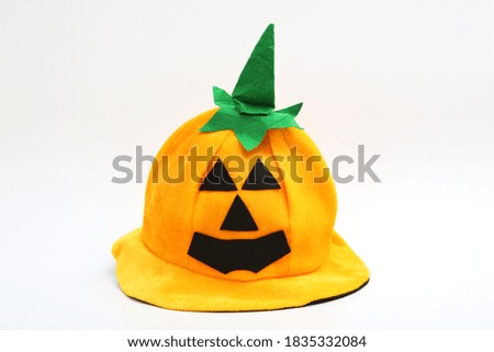 an orange pumpikin halloween hat with green on top isolated white background