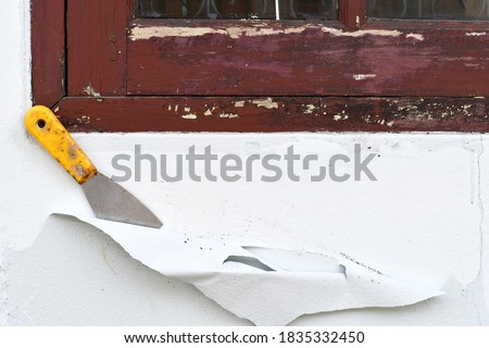 Concept for home renovation and exterior paint work. Flakes of paint on concrete wall peeling off. Old paint surface removal. shattered wall, crack and decayed paint construction,Grunge texture.  Royalty-Free Stock Photo #1835332450