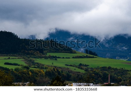 Dramatic low clouds at the mountains background by autumn