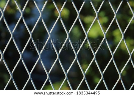 The view on the protecting metal mesh installed on the fence in the bridge 

