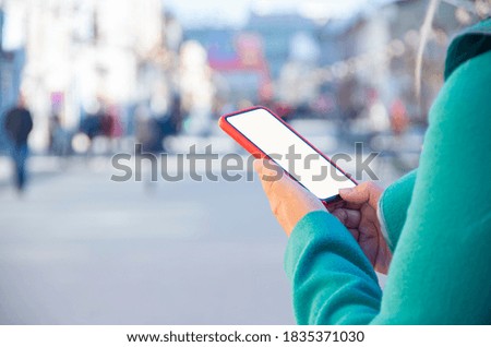 Closeup photo of female hands holding modern smartphone with blank screen. Mockup ready for text message or content. Woman's hands with cellphone. Empty display. 