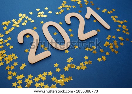 2021 numbers Merry Christmas and Happy New Year on Blue background with golden stars. Holiday texture. holiday party decoration.