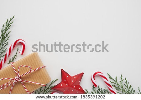 Christmas corner arrangement with gift, conifer branches and decorations on white background
