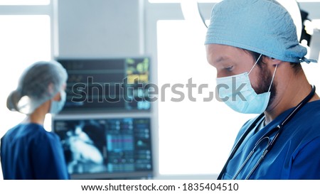 Professional medical doctors working in emergency medicine. Portrait of the surgeon and the nurse in protective masks performing surgical operation.