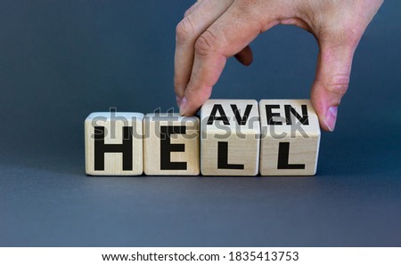 Hell or heaven. Hand turns cubes and changes the word 'hell' to 'heaven'. Concept. Beautiful grey background, copy space.