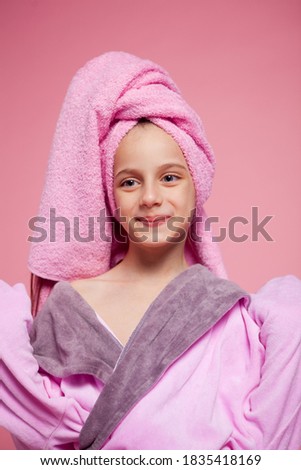 cute girl dressed in a terry bathrobe straightens her hair