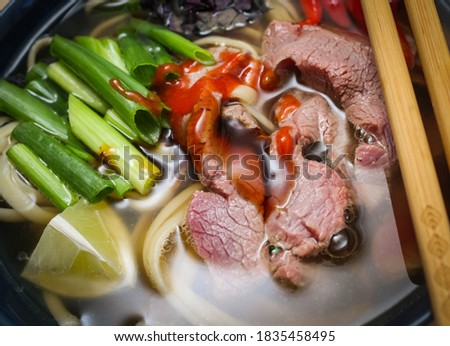 Pho Bo - Vietnamese fresh rice noodle soup with beef, herbs and basil. Vietnam's national dish.